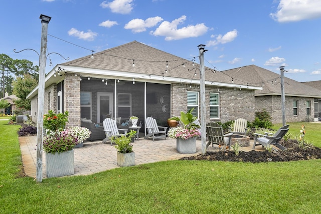 back of house featuring a yard, a fire pit, and a sunroom