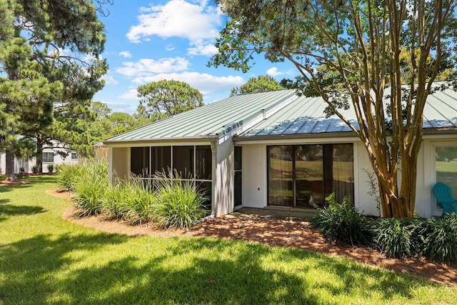 rear view of property featuring a lawn