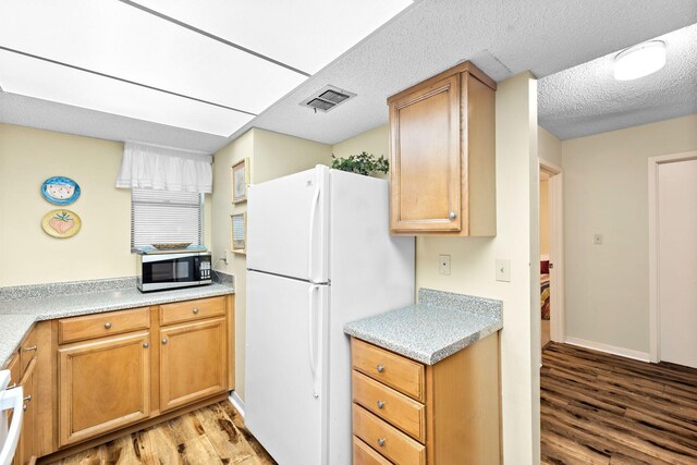 kitchen with light wood-type flooring and white refrigerator