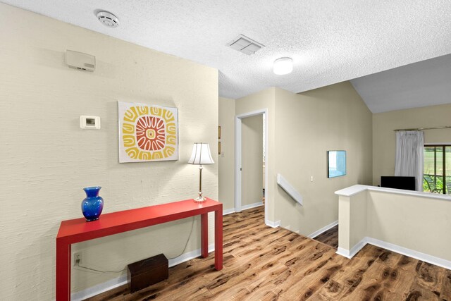 hallway featuring wood-type flooring and a textured ceiling