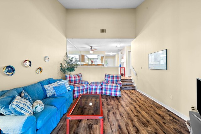 living room featuring ceiling fan, hardwood / wood-style floors, and a high ceiling