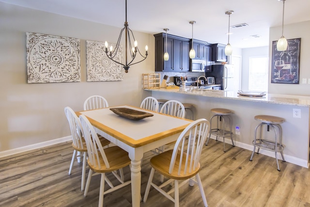 dining room with a chandelier, light hardwood / wood-style floors, and sink