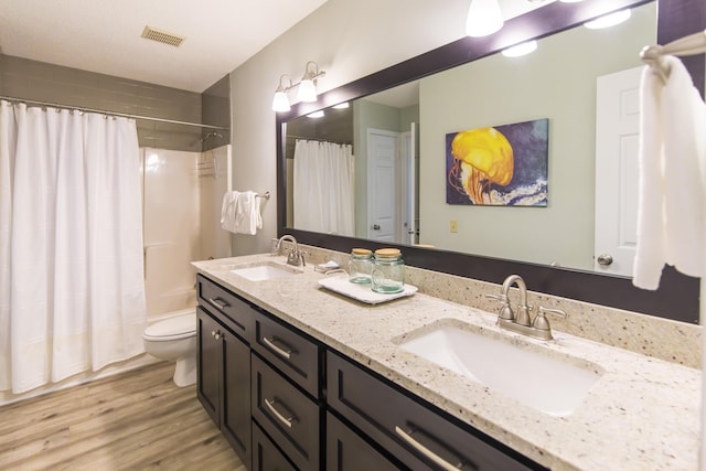 full bathroom with shower / tub combo, vanity, toilet, and hardwood / wood-style floors