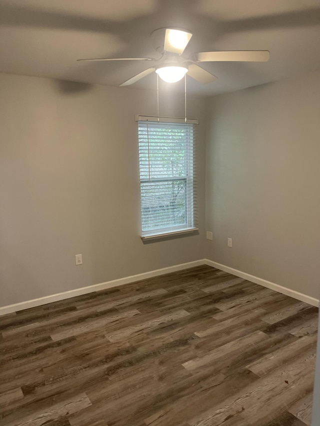 empty room with ceiling fan and dark hardwood / wood-style flooring