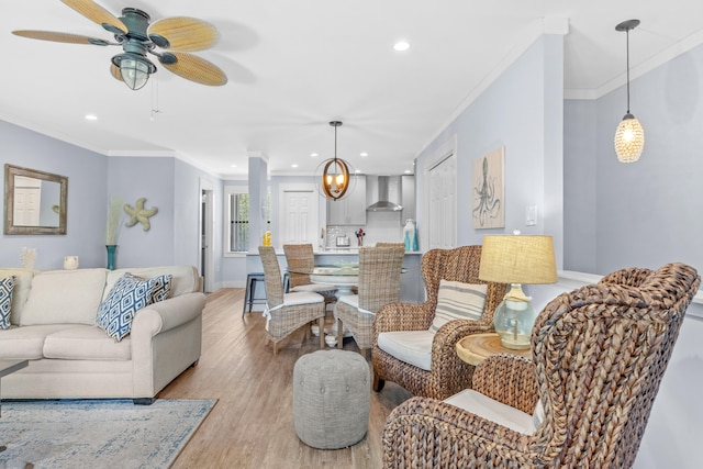 living room with ceiling fan, ornamental molding, and hardwood / wood-style floors