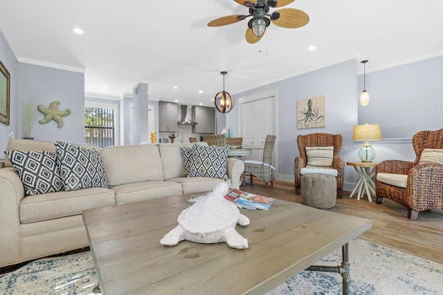 living room featuring hardwood / wood-style floors, ornamental molding, and ceiling fan