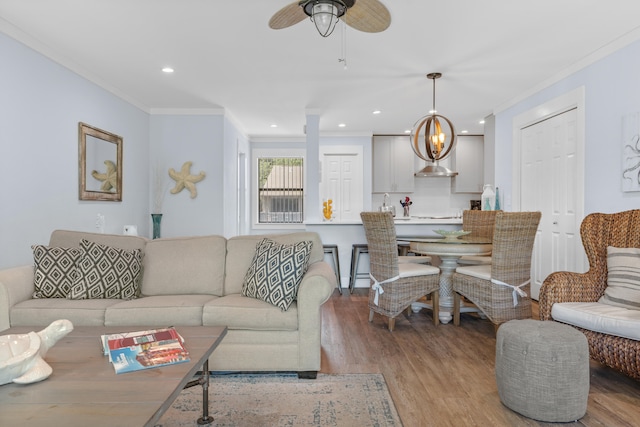 living room featuring ceiling fan, crown molding, and wood-type flooring