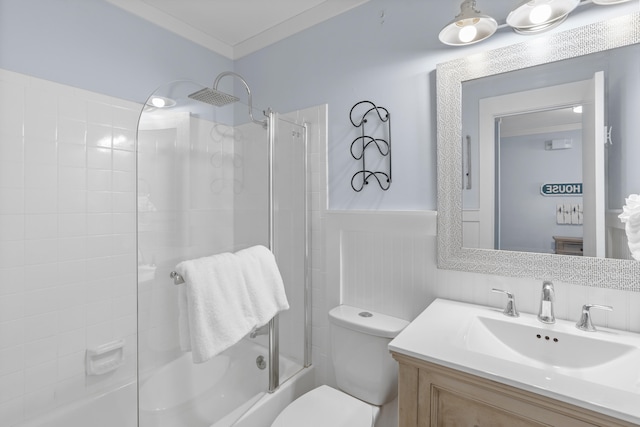 full bathroom featuring ornamental molding, toilet, bath / shower combo with glass door, and vanity