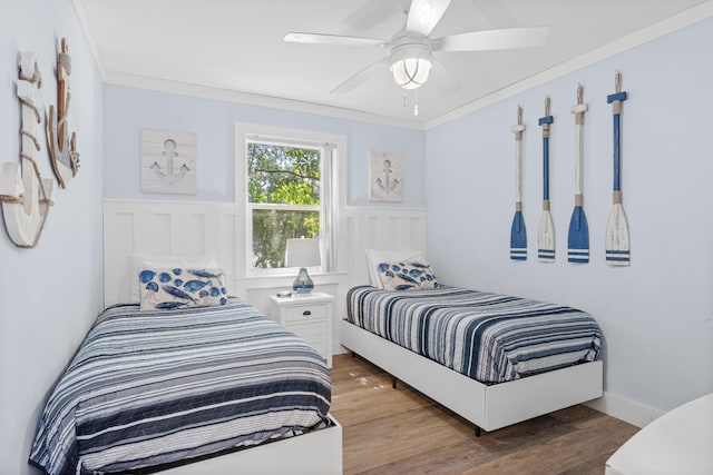 bedroom featuring crown molding, wood-type flooring, and ceiling fan