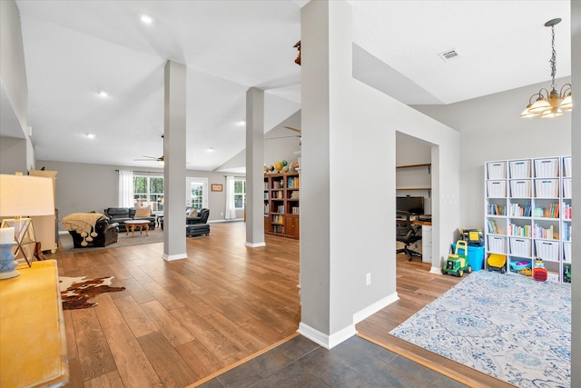 recreation room with hardwood / wood-style flooring, ceiling fan with notable chandelier, and lofted ceiling