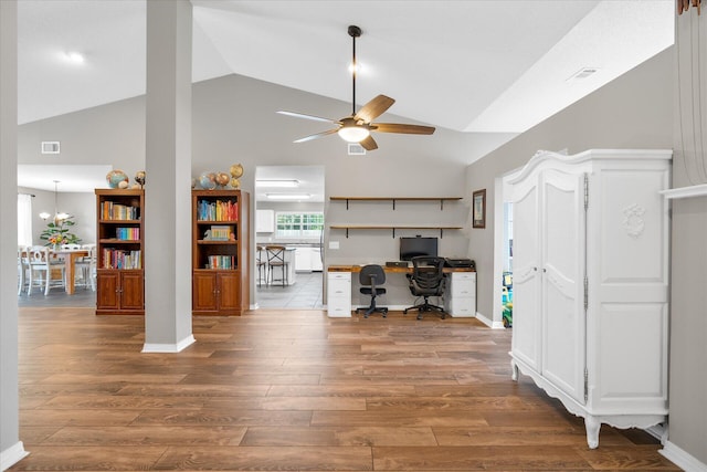 office space with hardwood / wood-style flooring, ceiling fan with notable chandelier, and high vaulted ceiling