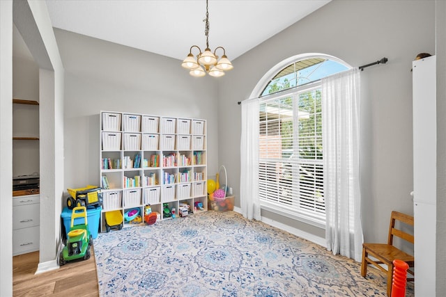 recreation room featuring light hardwood / wood-style floors and an inviting chandelier