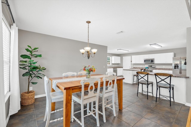 tiled dining area featuring a chandelier