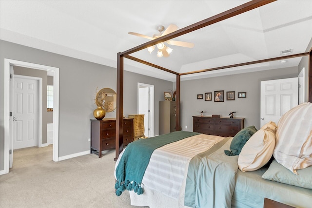 carpeted bedroom with ceiling fan and a raised ceiling