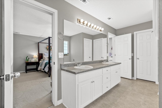 bathroom with tile patterned floors, vanity, and a textured ceiling