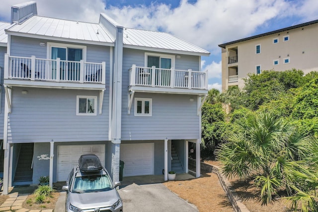 rear view of house with a balcony and a garage