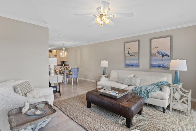 living room featuring ceiling fan, light wood-type flooring, and crown molding