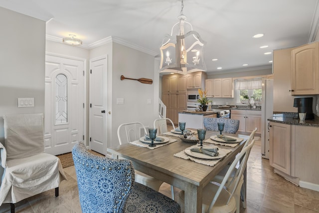 dining room with an inviting chandelier, crown molding, and sink