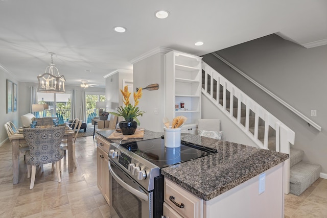 kitchen featuring a kitchen island, ornamental molding, high end stainless steel range, and an inviting chandelier