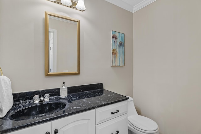 bathroom with toilet, vanity, and ornamental molding