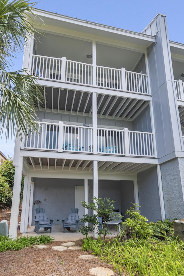 back of property featuring a patio area and a balcony