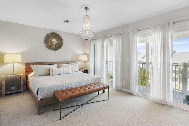 carpeted bedroom featuring access to exterior and a chandelier