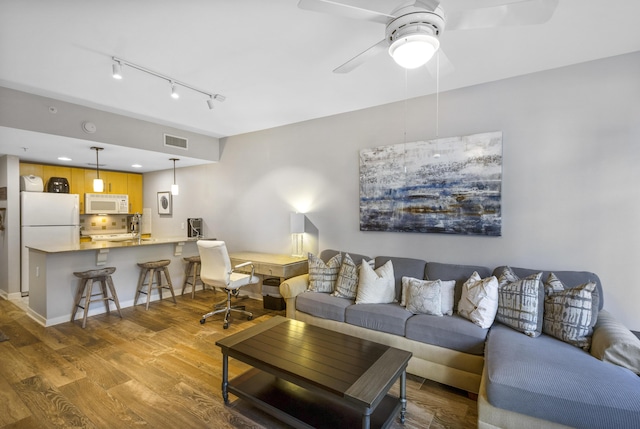 living room with ceiling fan and light hardwood / wood-style floors