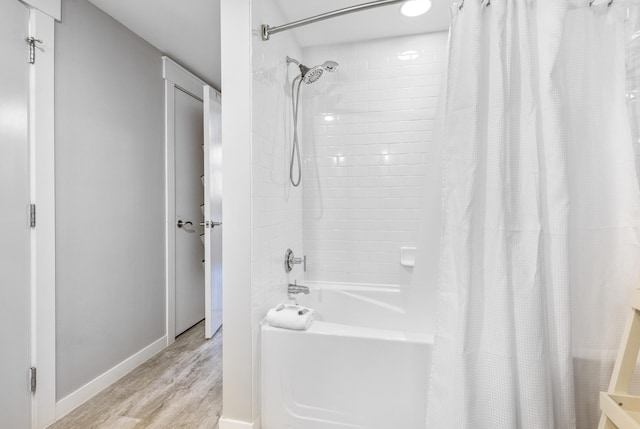 bathroom with hardwood / wood-style flooring and shower / bath combination with curtain