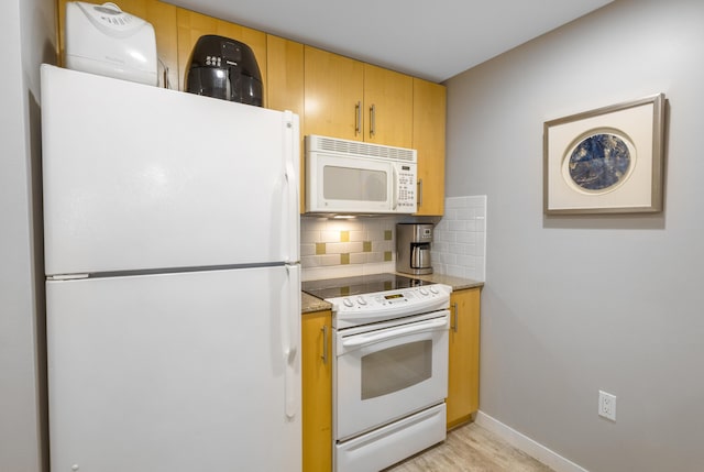 kitchen featuring light stone counters, white appliances, decorative backsplash, and light hardwood / wood-style flooring