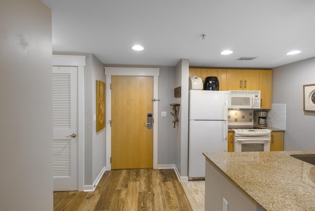 kitchen with white appliances, light stone counters, tasteful backsplash, light hardwood / wood-style floors, and light brown cabinetry