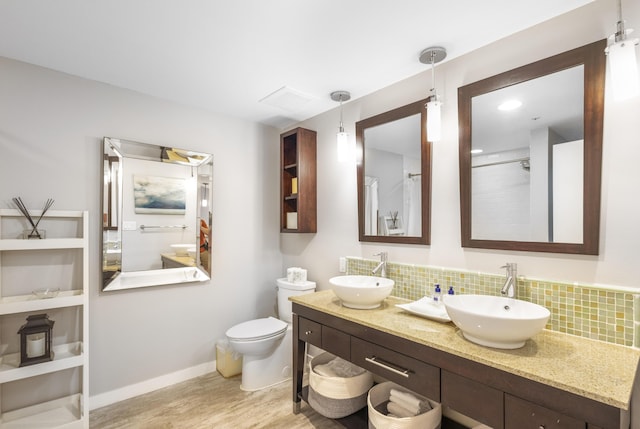 bathroom with tasteful backsplash, vanity, wood-type flooring, and toilet