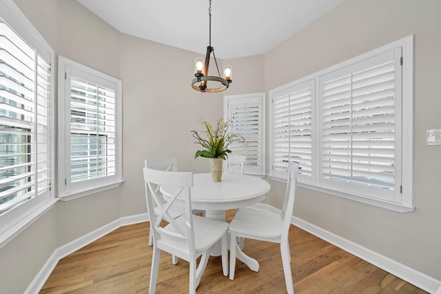 dining area with light hardwood / wood-style floors and a chandelier