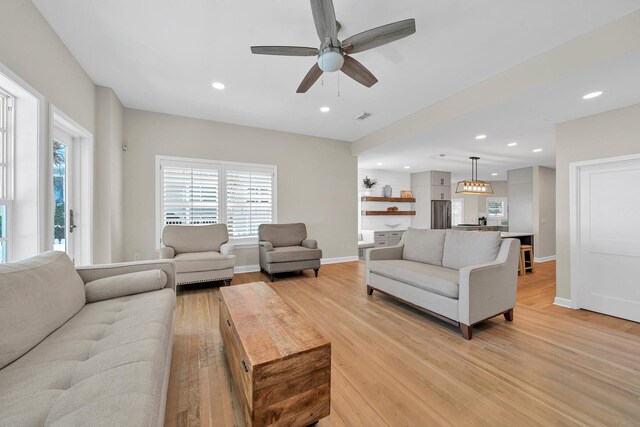 living room featuring ceiling fan and light hardwood / wood-style floors