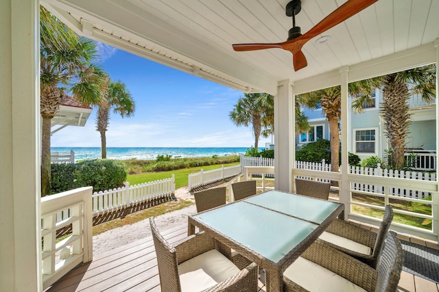 deck with ceiling fan and a water view