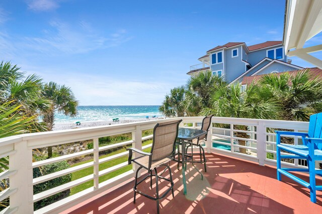 balcony featuring a view of the beach and a water view