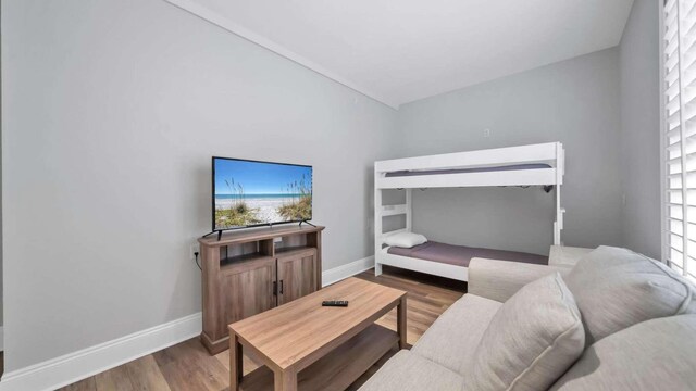 bedroom with hardwood / wood-style floors, lofted ceiling, and multiple windows