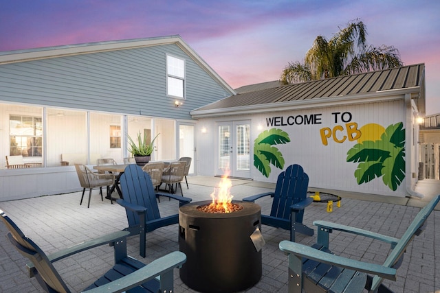 patio terrace at dusk with french doors and a fire pit