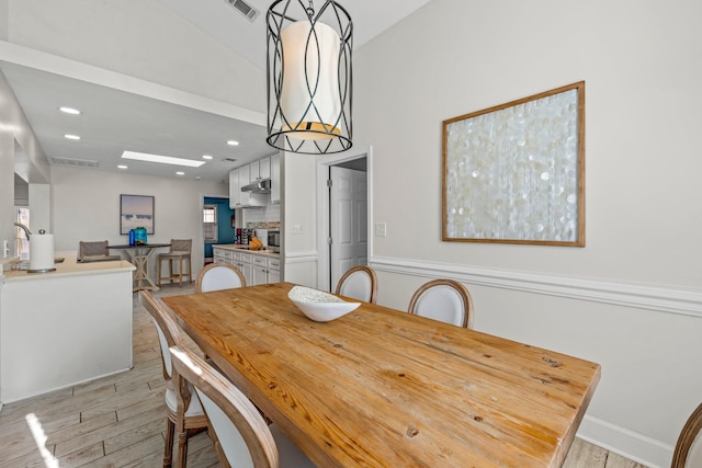 dining space featuring vaulted ceiling and light wood-type flooring