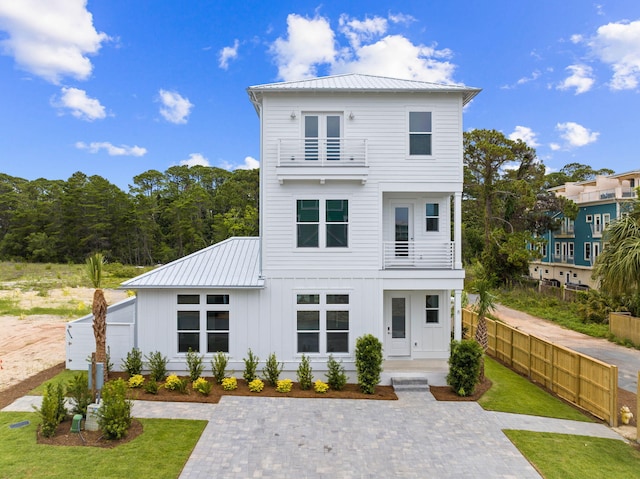 rear view of property featuring a lawn and a balcony