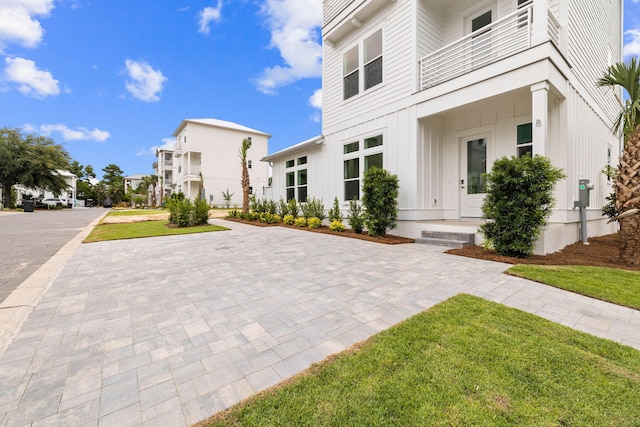 exterior space featuring a lawn and a balcony