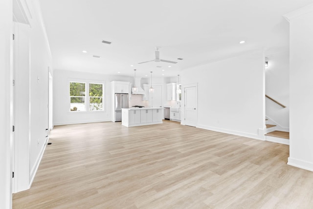 unfurnished living room with ceiling fan and light wood-type flooring