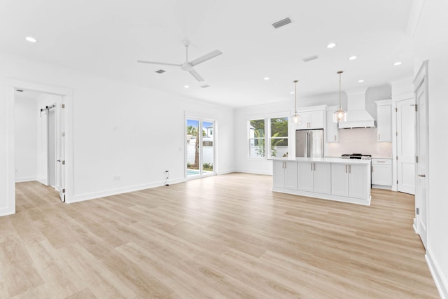 unfurnished living room featuring ceiling fan and light wood-type flooring