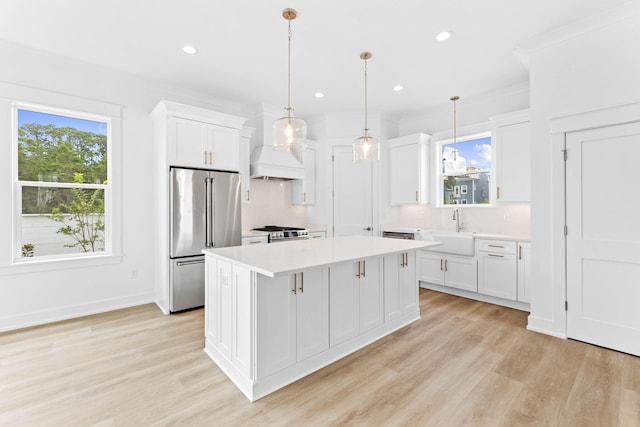 kitchen featuring a center island, white cabinets, hanging light fixtures, and appliances with stainless steel finishes