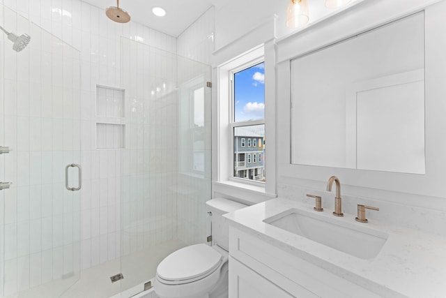 bathroom with vanity, a shower with shower door, and toilet