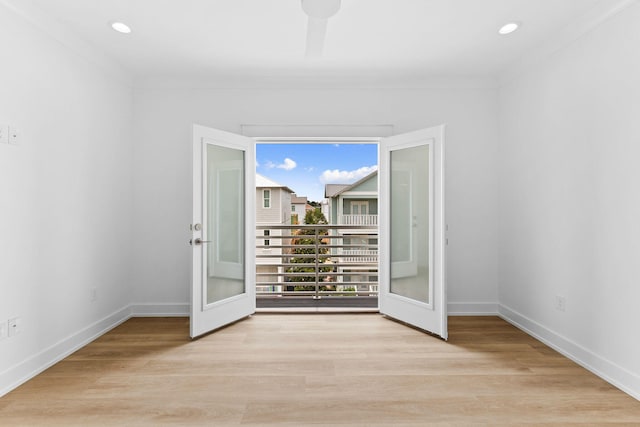 spare room featuring french doors, light hardwood / wood-style floors, and crown molding