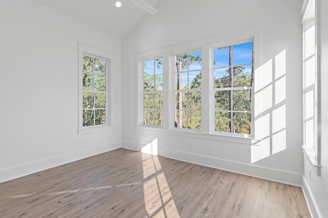 unfurnished sunroom featuring vaulted ceiling and a healthy amount of sunlight