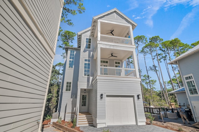 view of front facade with a balcony, a garage, and ceiling fan