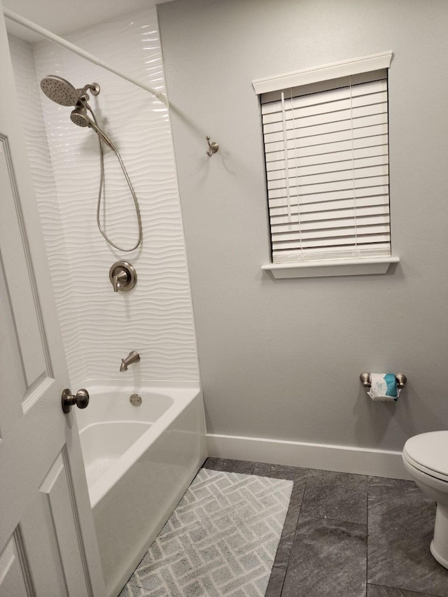 bathroom featuring tile patterned flooring, toilet, and tiled shower / bath