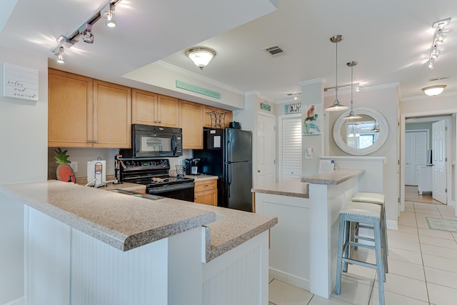 kitchen with a breakfast bar, black appliances, crown molding, light tile patterned flooring, and kitchen peninsula