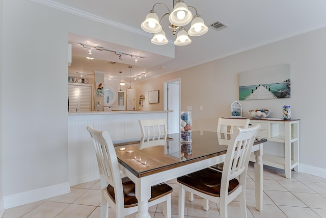 dining space with a chandelier, light tile patterned floors, and crown molding